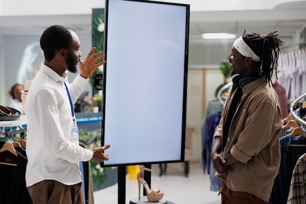 Photo employé utilisant un écran intelligent pour aider le client à acheter