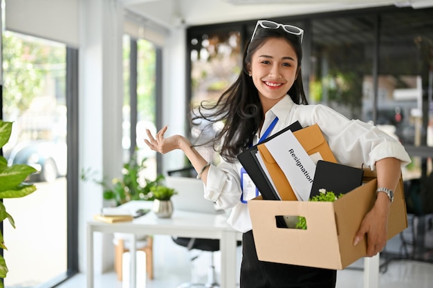 Employée de bureau asiatique souriante célébrant sa démission heureuse de quitter son emploi