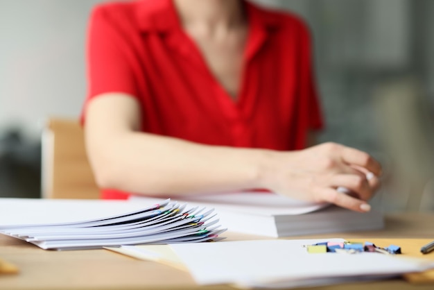 Une employée de bureau en chemisier rouge cherche des documents une femme travaille avec des papiers fixant des feuilles