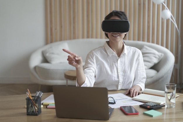 Employée de bureau dans un casque vr ou des lunettes de réalité virtuelle touchant des objets dans le cyberespace