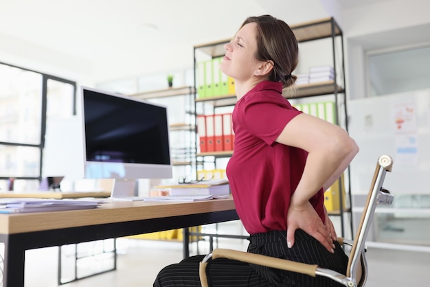 Photo employée de bureau avec douleur au bas du dos sur le lieu de travail