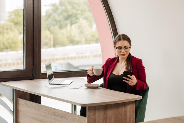 Employée de bureau ou secrétaire buvant du café pendant la journée de travail au bureau