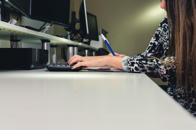 Employée dans un bureau de programmation de logiciels écrivant des notes de clients copiez l'espace