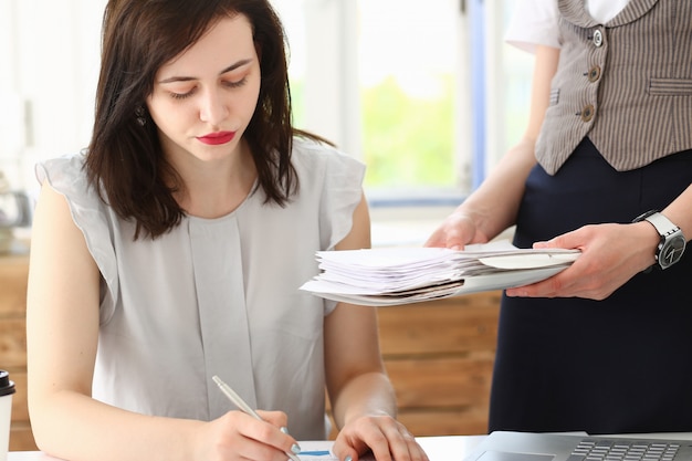 Employée montrer un pack de documents au gestionnaire