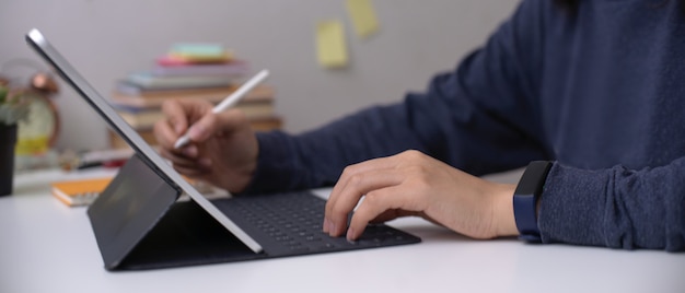Employée travaillant sur tablette numérique avec stylet sur bureau