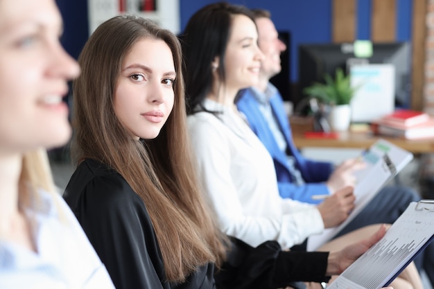 Employés d'affaires assis à la conférence de formation avec des graphiques commerciaux