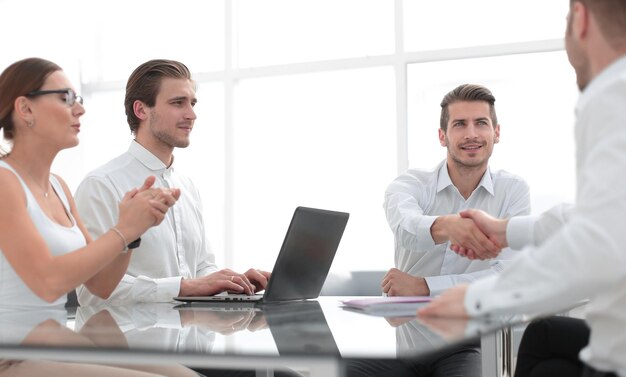 Les employés applaudissent les partenaires commerciaux à la table de négociation