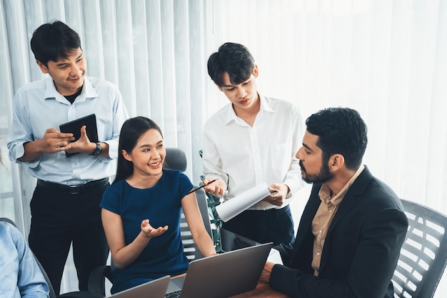 Employés de bureau asiatiques au bureau discutant et travaillant ensemble Concord