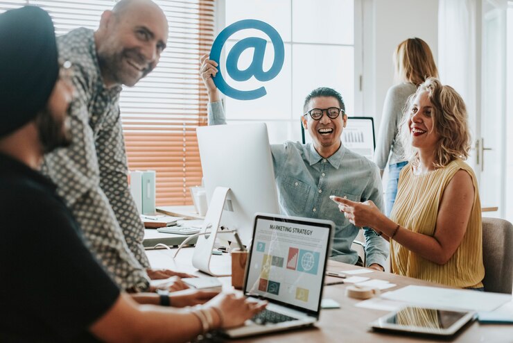 Photo employés dans un bureau tenant une pancarte