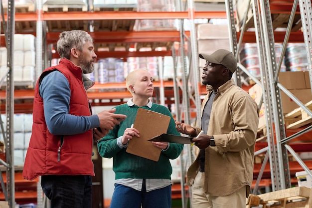 Les employés d'entrepôt discutent du retard de la cargaison