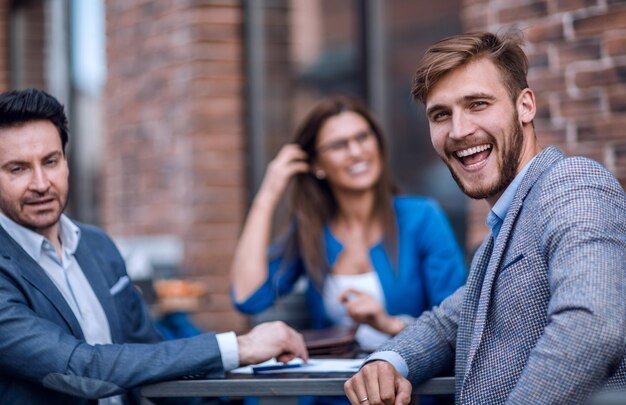 Employés de l'entreprise assis à une table dans un café de rue