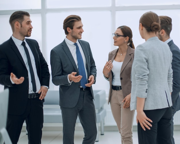 Les employés de l'entreprise discutent de la position debout au bureau en semaine