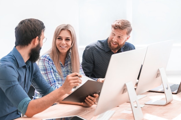 Employés joyeux discutant de quelque chose lors d'une réunion au bureau. le concept de travail d'équipe