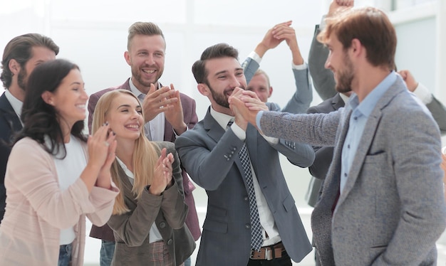 Employés joyeux félicitant un collègue pour la promotion