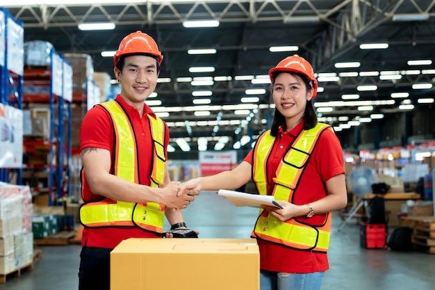 Employés masculins et féminins se serrant la main avec des offres dans la collaboration de succès d'entrepôt