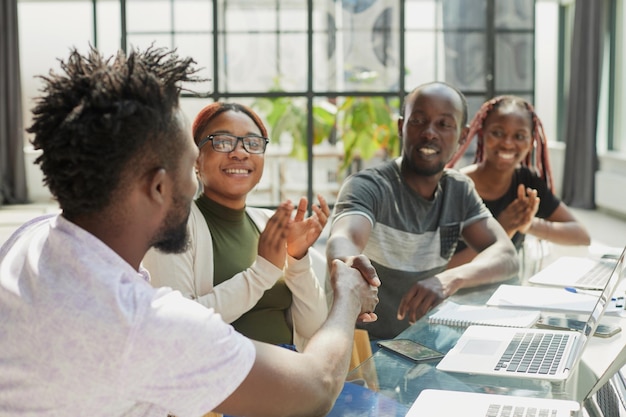 Employés masculins en vêtements formels faisant une poignée de main lors d'une réunion d'affaires au bureau