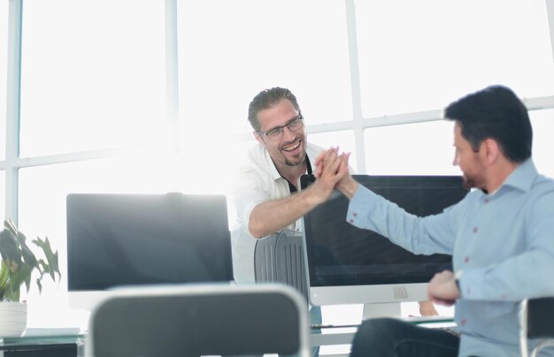 Les employés se donnent un high five sur le concept de réussite du bureau de l'ordinateur