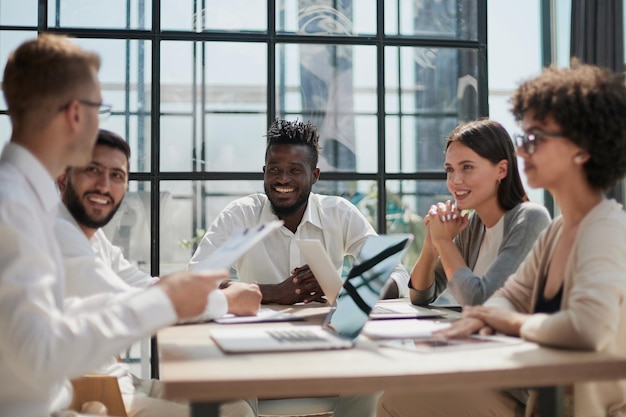 Employés travaillant à l'ordinateur ensemble discutant du contenu