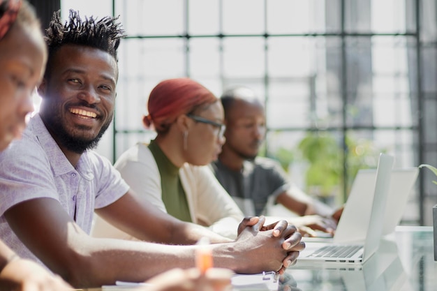 Employés travaillant à l'ordinateur ensemble discutant du contenu