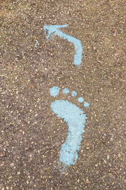 Photo empreinte bleue des signes sur le sol dans la forêt pour les piétons. symbole de passerelle.