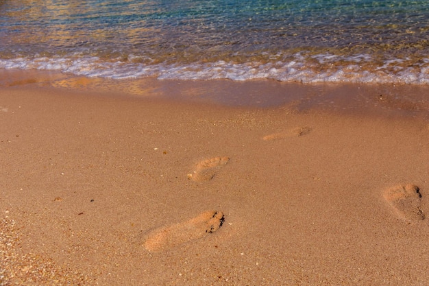 Empreintes humaines sur la plage de sable Concept de vacances d'été
