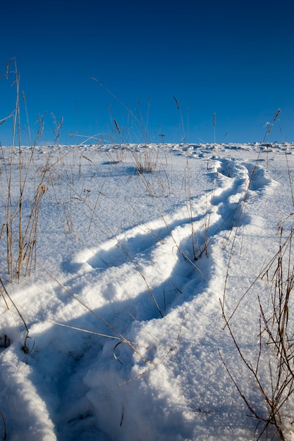 Empreintes de pas sur les congères après avoir marché dans la neige d'une personne, la saison d'hiver dans la nature