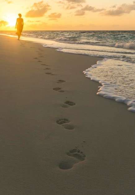 Empreintes de pas dans le sable sur une plage tropicale