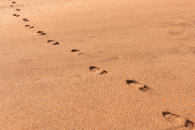 Empreintes de pas humaines sur le sable lâche jaune