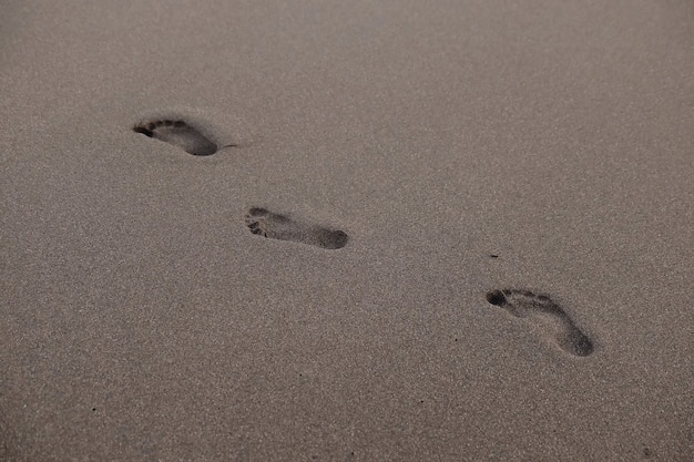 Empreintes de pas sur la plage pendant le coucher du soleil en été