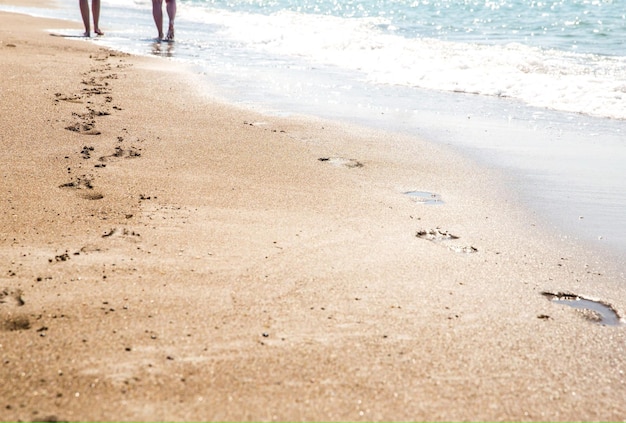 Empreintes de pas sur le sable d'un couple marchant