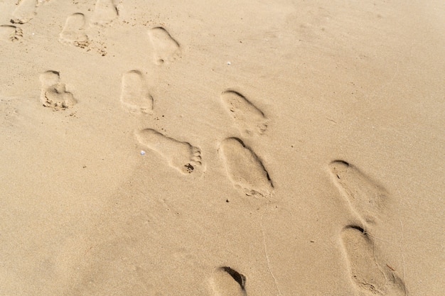 Empreintes de pas sur le sable de la plage, l'été.