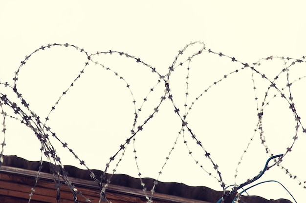 emprisonnement, concept de restriction - clôture en fil de fer barbelé sur ciel gris