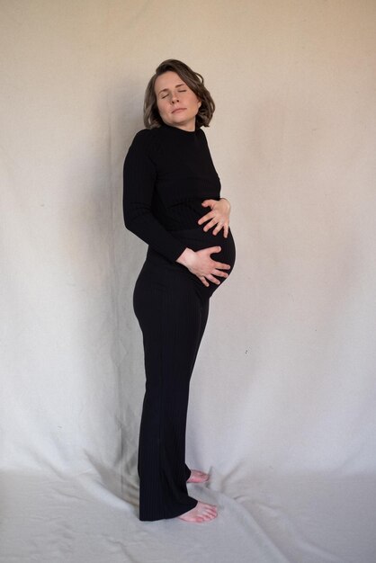 Enceinte caucasienne femme souriante qui pose en studio