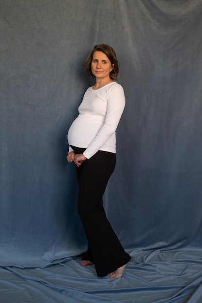 Enceinte caucasienne femme souriante qui pose en studio