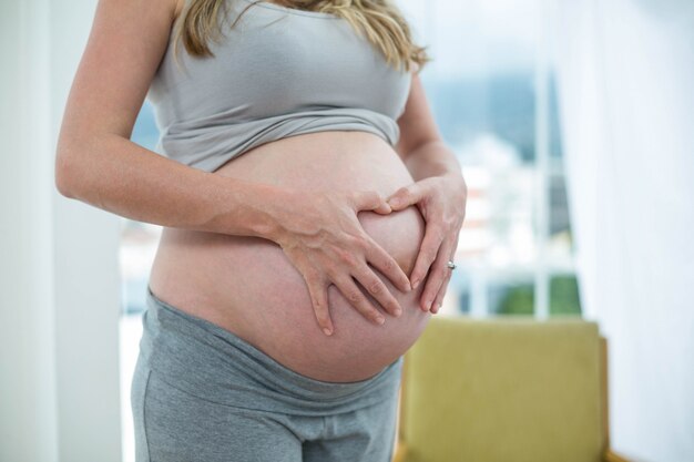 Enceinte femme tenant son ventre dans la chambre