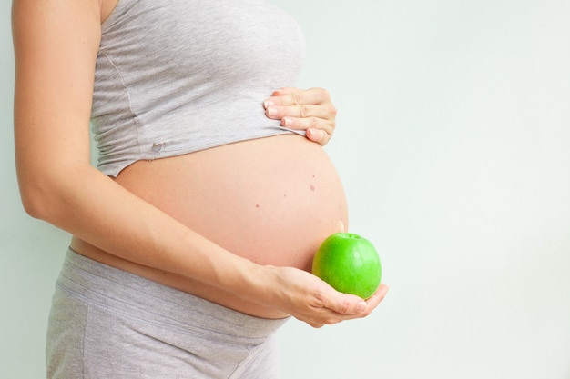 Enceinte fille tenant une pomme verte