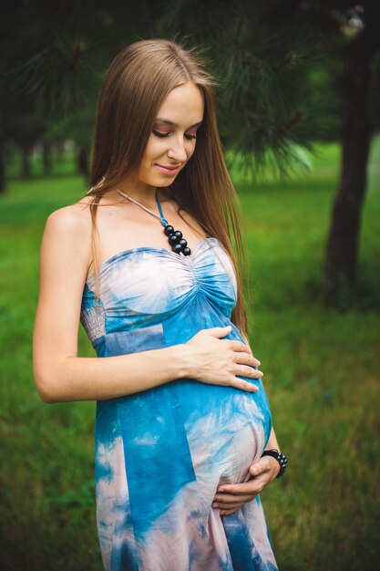 Enceinte jeune couple dans le parc d'été.