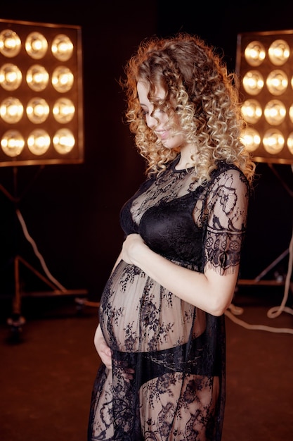 Enceinte jeune mannequin blonde belle mode femme en studio en sous-vêtements noirs attendre bébé