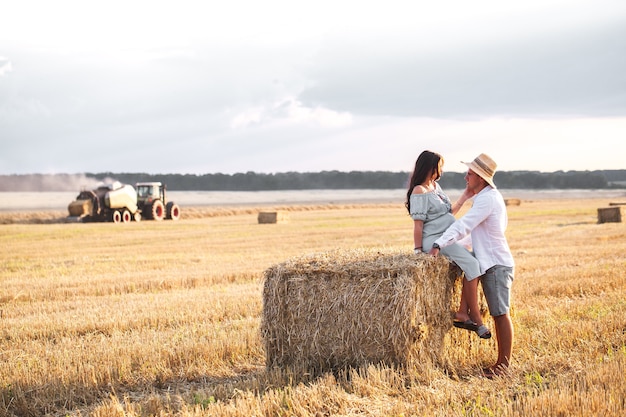 Enceinte avec son mari dans la crèche. Beau couple avec tournesols