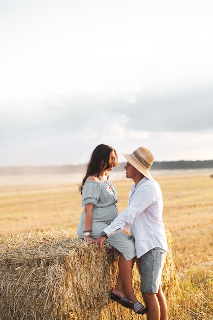 Enceinte avec son mari dans la crèche. Beau couple avec tournesols