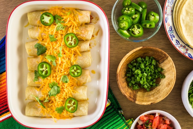 Enchiladas au poulet avec fromage cheddar et sauce.