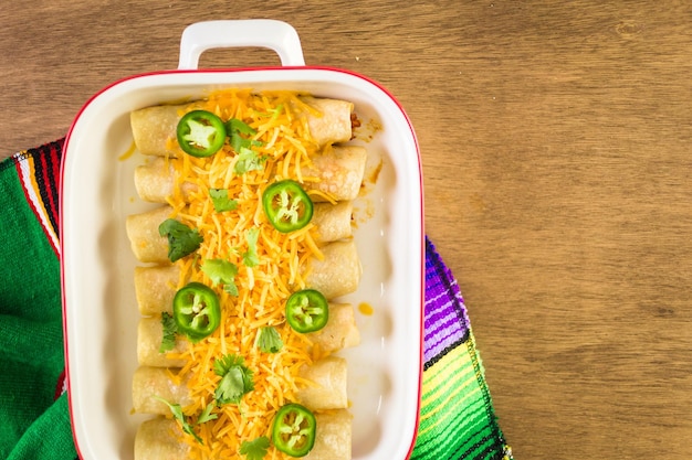 Enchiladas au poulet avec fromage cheddar et sauce.