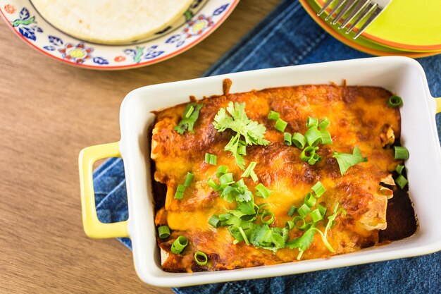 Enchiladas au poulet avec fromage cheddar et sauce.