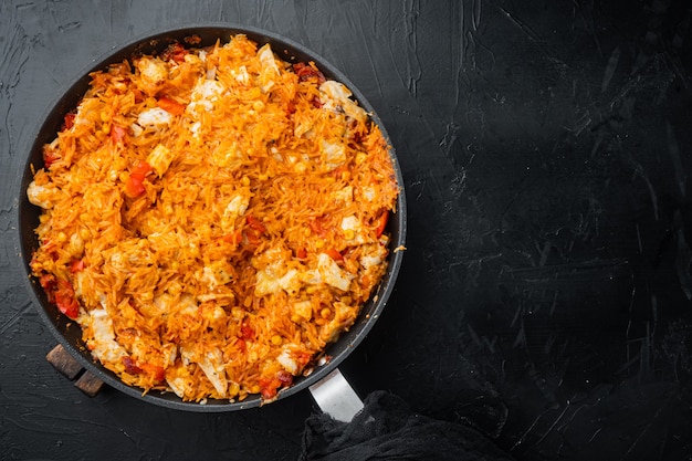 Enchiladas au poulet, servis en cocotte, sur fond noir, vue de dessus à plat avec copie espace pour le texte