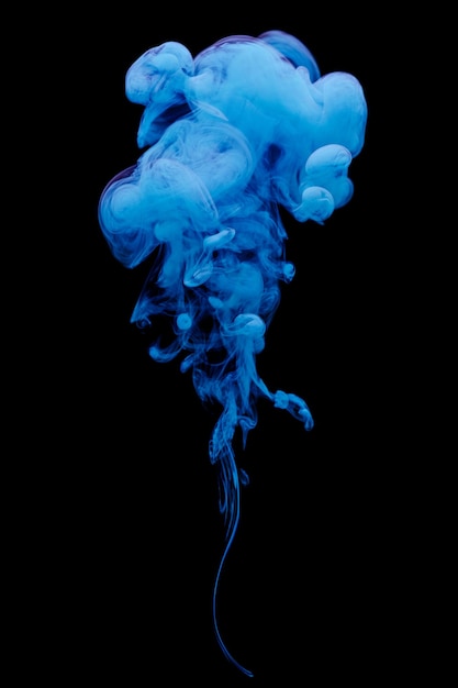 Encre bleue tourbillonnant dans l'eau isolée sur fond noir