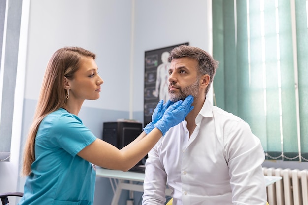 Endocrinologue examinant la gorge d'un homme en clinique Hommes avec test de la glande thyroïde Hormones et traitement endocrinologiques Inflammation du mal de gorge