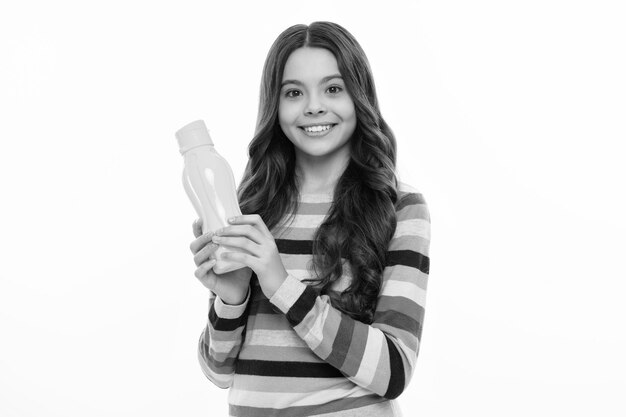 Photo enfant 12 13 14 ans avec une bouteille d'eau arrière-plan de studio isolé bouteilles d'eau et vie saine santé et équilibre de l'eau fille heureuse face à des émotions positives et souriantes