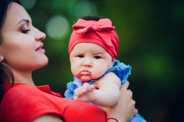 Enfant de 3 mois dans les mains de maman à l'extérieur. Première marche pour un nouveau-né