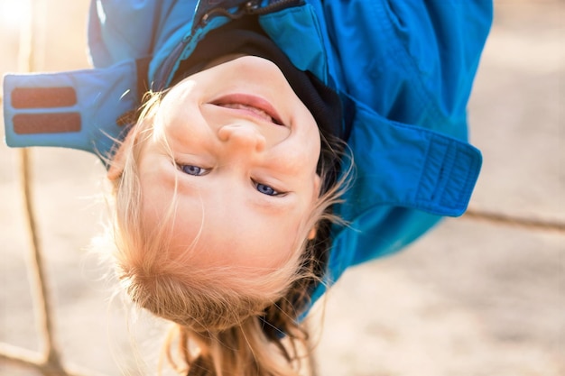 Enfant actif Amusez-vous sur le terrain de sport à l'envers. Vacances actives pour enfants sur une aire de jeux à l'extérieur.