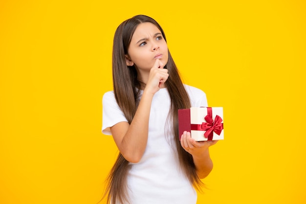 Enfant adolescent avec boîte-cadeau Présent pour les vacances Joyeux anniversaire Saint Valentin Nouvel An ou Noël Enfant tenir la boîte cadeau Pensée face aux émotions réfléchies d'une adolescente